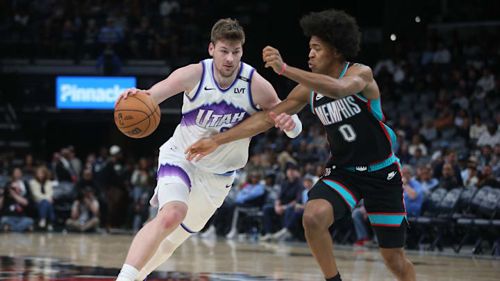 Feb 20, 2026; Memphis, Tennessee, USA; Utah Jazz forward Kyle Filipowski (22) drives against Memphis Grizzlies forward Jaylen Wells (0) during the third quarter at FedExForum. Mandatory Credit: Petre Thomas-Imagn Images
