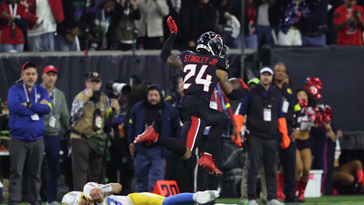 Jan 11, 2025; Houston, Texas, USA; Houston Texans corner back Derek Stingley Jr. (24) leaps over Los Angeles Chargers quarterback Justin Herbert (10) after an interception during the third quarter in an AFC wild card game at NRG Stadium. Mandatory Credit: Troy Taormina-Imagn Images