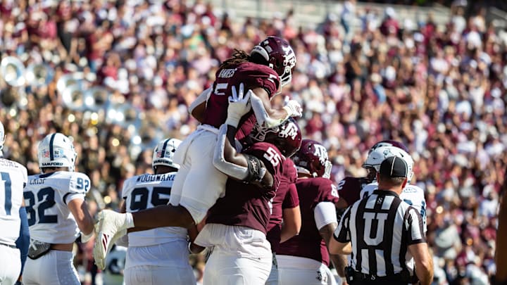 Texas A&M Aggies running back Amari Daniels (5) is lift into the air by offensive lineman Ar'maj Reed-Adams (55) in the first half of a game against the Samford Bulldogs at Kyle Field. 