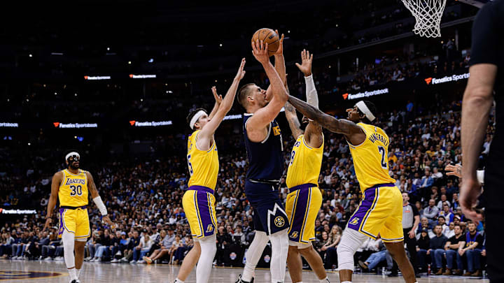 Mar 14, 2025; Denver, Colorado, USA; Denver Nuggets center Nikola Jokic (15) drives to the basket against Los Angeles Lakers forward Markieff Morris (88) and guard Austin Reaves (15) and forward Jarred Vanderbilt (2) in the second quarter at Ball Arena. Mandatory Credit: Isaiah J. Downing-Imagn Images