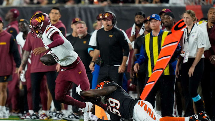 Washington Commanders quarterback Jayden Daniels breaks away from a Cincinnati Bengals linebacker Akeem Davis-Gaither.