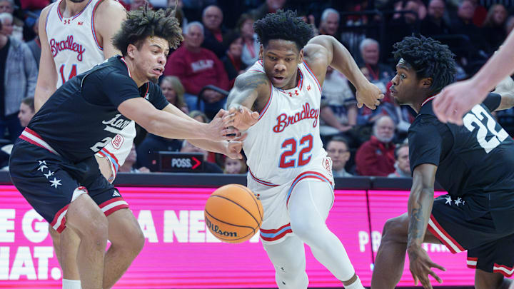 UIC's Elijah Crawford, left, and Mekhi Lowery, right, try to steal the ball from Bradley's Jaquan Johnson in the first half of their college basketball game Saturday, Jan. 24, 2026 at Carver Arena. The Braves fell to the Flames 85-70.