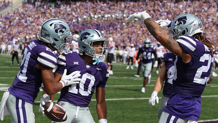 Sep 28, 2024; Manhattan, Kansas, USA; Kansas State Wildcats cornerback Jacob Parrish (10) celebrates with safety Marques Sigle (21) and linebacker Asa Newsom (23) after intercepting a pass against the Oklahoma State Cowboys in the third quarter at Bill Snyder Family Football Stadium. Mandatory Credit: Scott Sewell-Imagn Images