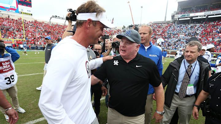 Sep 28, 2024; Oxford, Mississippi, USA; Mississippi Rebels head coach Lane Kiffin (left) and Kentucky Wildcats head coach Mark Stoops (right) embrace after the game at Vaught-Hemingway Stadium. Mandatory Credit: Petre Thomas-Imagn Images