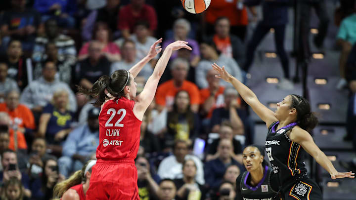 Sep 25, 2024; Uncasville, Connecticut, USA; Indiana Fever guard Caitlin Clark (22) shoots defended by Connecticut Sun guard Veronica Burton (22) during the second half during game two of the first round of the 2024 WNBA Playoffs at Mohegan Sun Arena. Mandatory Credit: Paul Rutherford-Imagn Images