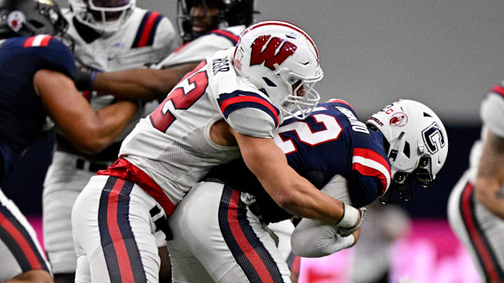 Jan 27, 2026; Frisco, TX, USA; East edge rusher Mason Reiger (22) sacks West quarterback Joe Fagnano (12) during the second half at the Ford Center at the Star. 