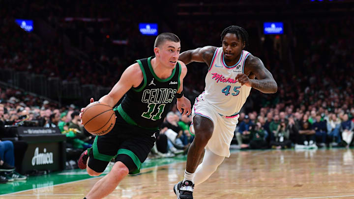 Apr 2, 2025; Boston, Massachusetts, USA; Boston Celtics guard Payton Pritchard (11) controls the ball while Miami Heat guard Davion Mitchell (45) defends during the second half at TD Garden. Mandatory Credit: Bob DeChiara-Imagn Images