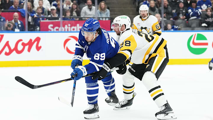 Oct 12, 2024; Toronto, Ontario, CAN; Toronto Maple Leafs left wing Nicholas Robertson (89) battles for the puck with Pittsburgh Penguins defenseman Marcus Pettersson (28) during the third period at Scotiabank Arena. Mandatory Credit: Nick Turchiaro-Imagn Images