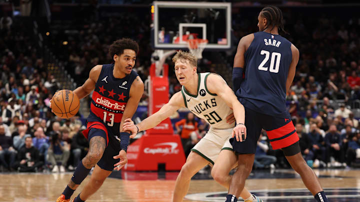 Feb 21, 2025; Washington, District of Columbia, USA; Washington Wizards guard Jordan Poole (13) dribbles the ball past Milwaukee Bucks guard AJ Green (20) as Wizards forward Alex Sarr (20) sets a screen in the second half at Capital One Arena. Mandatory Credit: Geoff Burke-Imagn Images