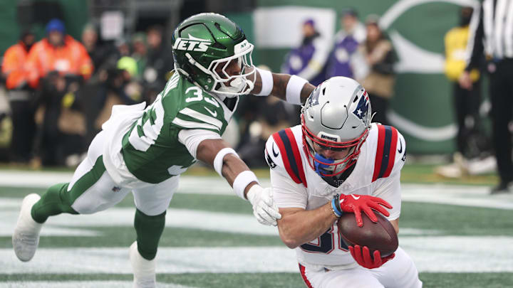 Dec 28, 2025; East Rutherford, New Jersey, USA; New England Patriots wide receiver Efton Chism III (86) makes a touchdown catch against New York Jets cornerback Jordan Clark (33) during the second half of the game at MetLife Stadium. Mandatory Credit: Vincent Carchietta-Imagn Images
