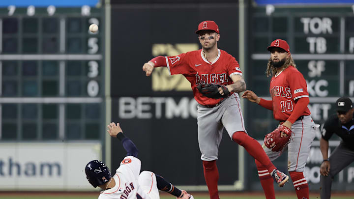 Sep 21, 2024; Houston, Texas, USA; Los Angeles Angels shortstop Zach Neto (9) turns a double play against Houston Astros left fielder Mauricio Dubon (14) in the fourth inning at Minute Maid Park. Mandatory Credit: Thomas Shea-Imagn Images
