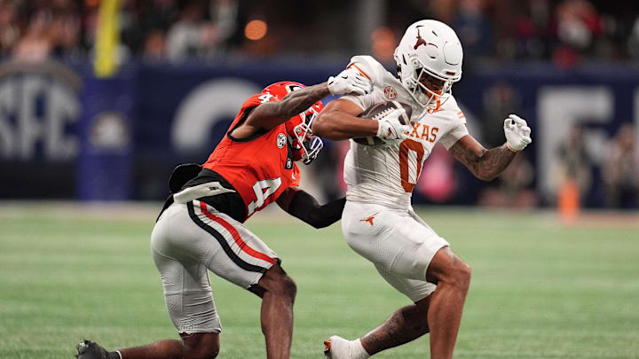 Dec 7, 2024; Atlanta, GA, USA; Georgia Bulldogs defensive back KJ Bolden (4) makes a tackle on Texas Longhorns wide receiver DeAndre Moore Jr. (0) during the first half in the 2024 SEC Championship game at Mercedes-Benz Stadium. Mandatory Credit: Dale Zanine-Imagn Images