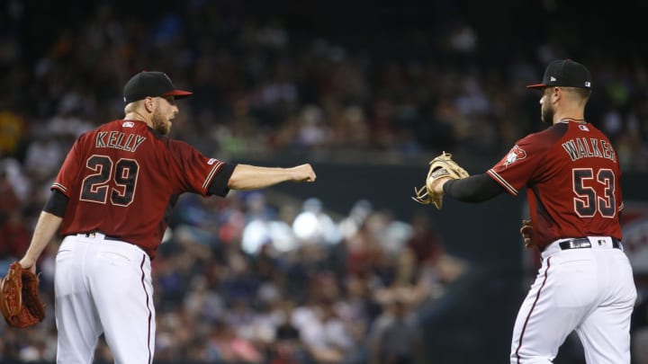 Diamondbacks' Merrill Kelly (29) bumps fists with first basemen Christian Walker (53) Diamondbacks' Merrill Kelly (29) bumps fists with first basemen Christian Walker (53)