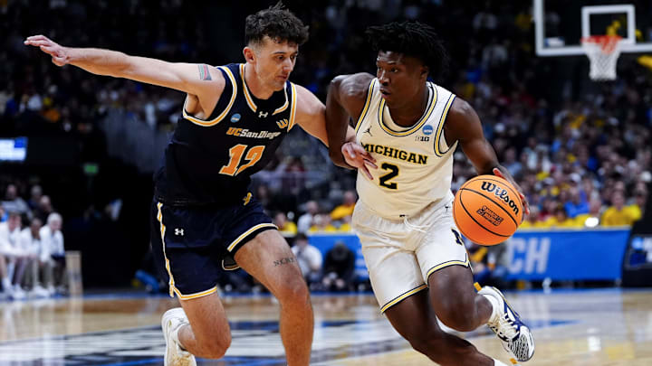 March 20, 2025; Denver, CO, USA; Michigan Wolverines guard L.J. Cason (2) drives as UC San Diego Tritons guard Aniwaniwa Tait-Jones (12) defends during the first half at Ball Arena. Mandatory Credit: Ron Chenoy-Imagn Images