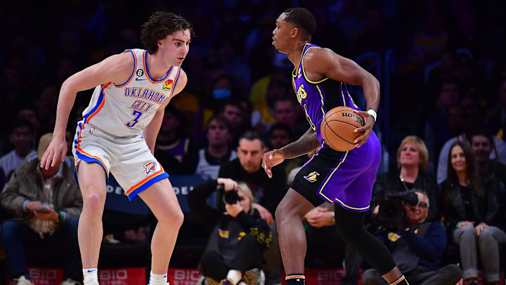 Mar 24, 2023; Los Angeles, California, USA; Los Angeles Lakers guard Lonnie Walker IV (4) moves the ball against Oklahoma City Thunder guard Josh Giddey (3) during the first half at Crypto.com Arena. Mandatory Credit: Gary A. Vasquez-Imagn Images
