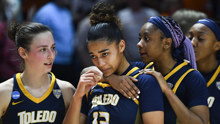 Toledo's Jayda Jansen (12) is encouraged by teammates Sophia Wiard (2) and Quinesha Lockett (5)