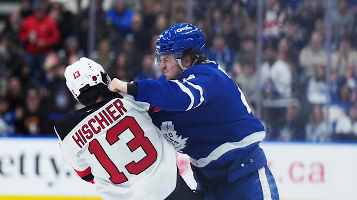 Toronto Maple Leafs left wing Matthew Knies (23) fights with New Jersey Devils center Nico Hischier (13): Nick Turchiaro-Imagn Images