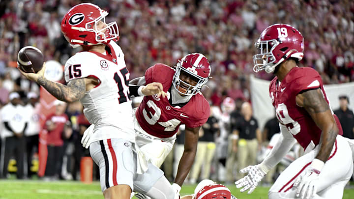 Sep 28, 2024; Tuscaloosa, Alabama, USA;  Georgia Bulldogs quarterback Carson Beck (15) is penalized for grounding as he is pressured in the end zone by Alabama Crimson Tide linebacker Que Robinson (34) and linebacker Keanu Koht (19) resulting in a safety at Bryant-Denny Stadium. Mandatory Credit: Gary Cosby Jr.-Imagn Images