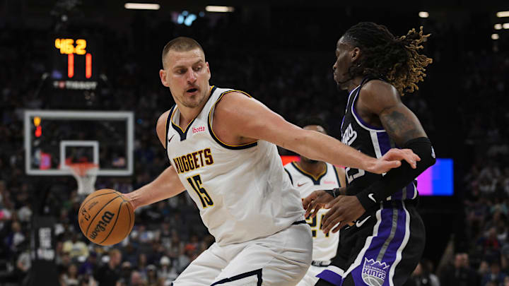 Apr 9, 2025; Sacramento, California, USA; Denver Nuggets center Nikola Jokic (15) controls the ball against Sacramento Kings guard Keon Ellis (23) during the second quarter at Golden 1 Center. Mandatory Credit: Ed Szczepanski-Imagn Images