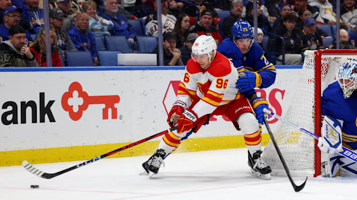 Nov 9, 2024; Buffalo, New York, USA;  Calgary Flames left wing Andrei Kuzmenko (96) controls the puck as Buffalo Sabres defenseman Owen Power (25) tries to defend during the first period at KeyBank Center. Mandatory Credit: Timothy T. Ludwig-Imagn Images