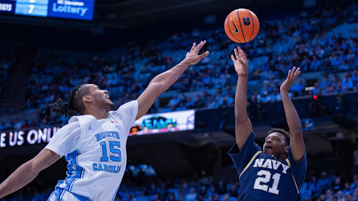 Nov 18, 2025; Chapel Hill, North Carolina, USA; Navy Midshipmen guard Jordan Pennick (21) shoots over North Carolina Tar Heels forward Jarin Stevenson (15) during the first half at Dean E. Smith Center. Mandatory Credit: Scott Kinser-Imagn Images