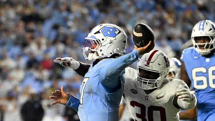 Nov 8, 2025; Chapel Hill, North Carolina, USA; North Carolina Tar Heels quarterback Gio Lopez (7) passes the ball as Stanford Cardinal linebacker Ese Dubre (30) pressures in the third quarter at Kenan Stadium. 