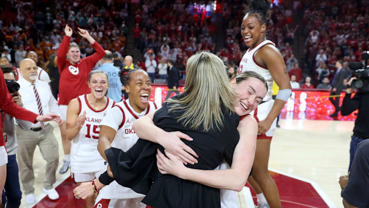 Oklahoma Sooners guard Payton Verhulst hugs Oklahoma coach Jennie Baranczyk in front of guard Lexy