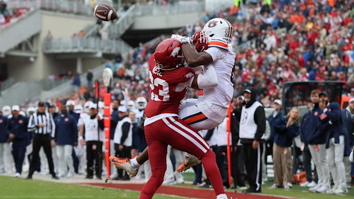 Oct 25, 2025; Fayetteville, Arkansas, USA; Auburn Tigers wide receiver Cam Coleman (8) receives a pass for a touchdown as Arkansas Razorbacks defensive back Julian Neal (23) defends during the first quarter at Donald W. Reynolds Razorback Stadium. Mandatory Credit: Nelson Chenault-Imagn Images