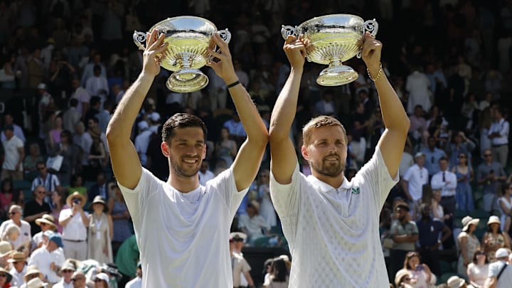 Jul 12, 2025; Wimbledon, United Kingdom; (L-R) Julian Cash (GBR) and Lloyd Glasspool (GBR) celebrate with the gentlemen's doubles championship trophies after their match against Rinky Hijikata (AUS) and David Pel (NED)(both not pictured) on day thirteen of The Championships Wimbledon 2025 at All England Lawn Tennis and Croquet Club. Mandatory Credit: Geoff Burke-Imagn Images