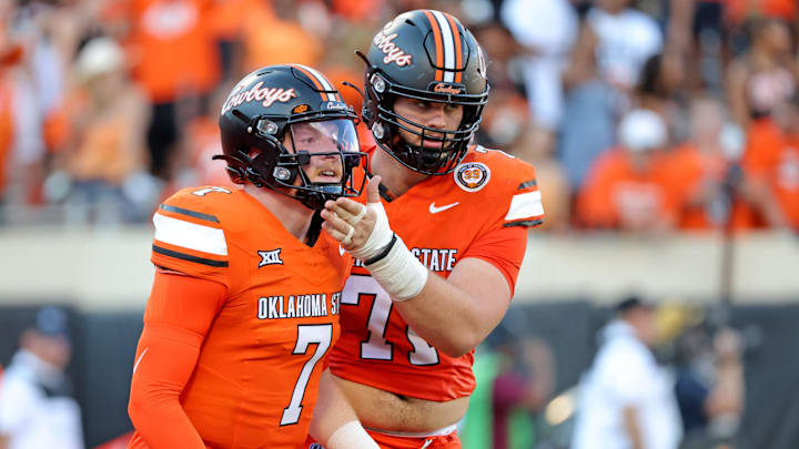 Oklahoma State's Dalton Cooper (71) holds up Alan Bowman's chin after he threw a interception late in the fourth quarter of the college football between the Oklahoma State University Cowboys and the Utah Utes at Boone Pickens Stadium in Stillwater, Okla., Saturday, Sept., 21, 2024.