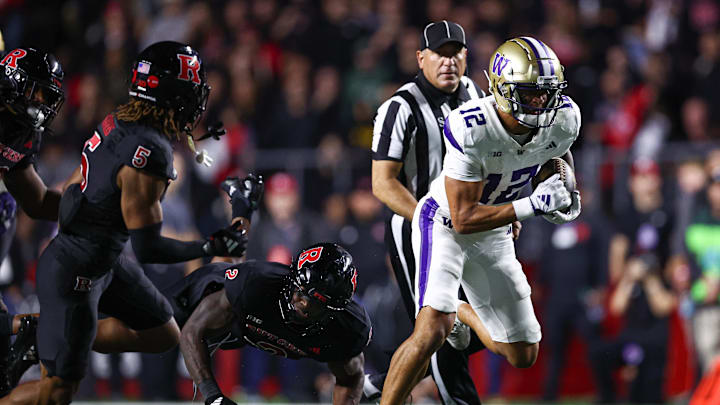 Sep 27, 2024; Piscataway, New Jersey, USA; Washington Huskies wide receiver Denzel Boston (12) breaks a tackle by Rutgers Scarlet Knights linebacker Moses Walker (2) for a touchdown during the second half at SHI Stadium. Mandatory Credit: Vincent Carchietta-Imagn Images