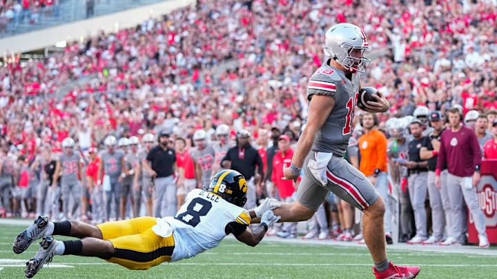 Oct 5, 2024; Columbus, OH, USA; Ohio State Buckeyes quarterback Will Howard (18) runs for a touchdown past Iowa Hawkeyes defensive back Deshaun Lee (8) during the second half of the NCAA football game at Ohio Stadium. Ohio State won 35-7.