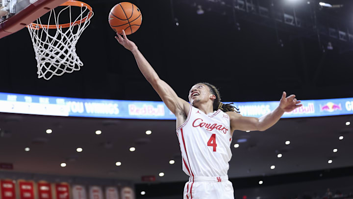 Dec 13, 2025; Houston, Texas, USA; Houston Cougars guard Kingston Flemings (4) scores a basket as New Orleans Privateers forward MJ Thomas (23) defends during the first half at Fertitta Center.