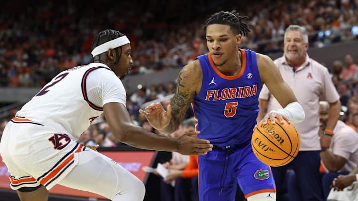 Feb 8, 2025; Auburn, Alabama, USA;  Florida Gators guard Will Richard (5) moves to the basket as Auburn Tigers guard Denver Jones (2) defends during the first half at Neville Arena. Mandatory Credit: John Reed-Imagn Images