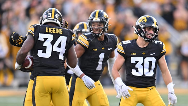 Oct 7, 2023; Iowa City, Iowa, USA; Iowa Hawkeyes linebacker Jay Higgins (34) and defensive back Xavier Nwankpa (1) and defensive back Quinn Schulte (30) react after an interception by Higgins against the Purdue Boilermakers during the fourth quarter at Kinnick Stadium.  