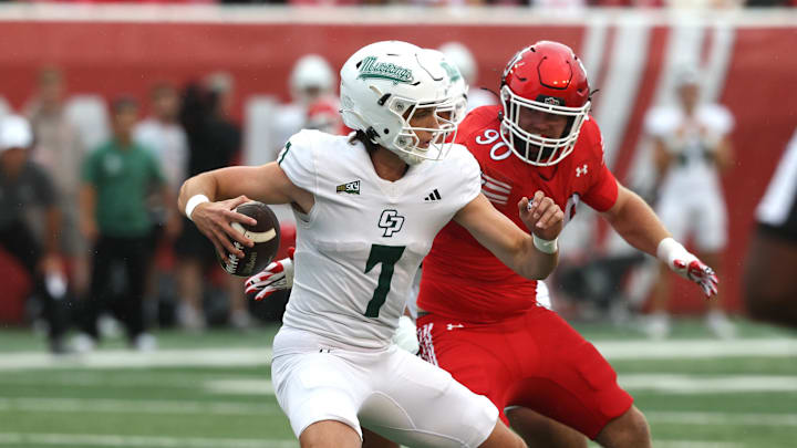 Sep 6, 2025; Salt Lake City, Utah, USA; Cal Poly Mustangs quarterback Ty Dieffenbach (7) avoids a tackle by Utah Utes defensive end John Henry Daley (90) during the first quarter at Rice-Eccles Stadium. Mandatory Credit: Rob Gray-Imagn Images