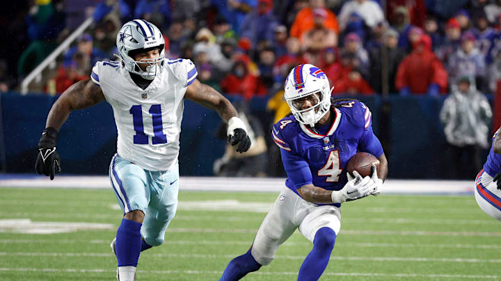 Buffalo Bills running back James Cook (4) gets extra yards as he runs past Dallas Cowboys linebacker Micah Parsons (11)