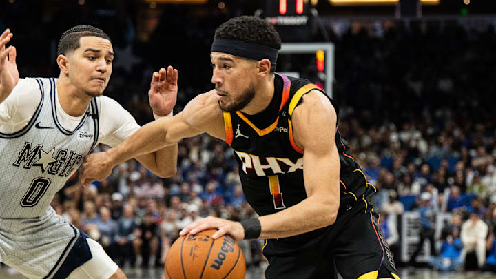 Phoenix Suns guard Devin Booker dribbles the ball against Orlando Magic guard Jett Howard.