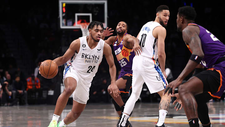Feb 7, 2023; Brooklyn, New York, USA; Brooklyn Nets guard Cam Thomas (24) dribbles as Phoenix Suns forward Mikal Bridges (25) fights through a screen by guard Ben Simmons (10) during the first quarter at Barclays Center. Mandatory Credit: Vincent Carchietta-Imagn Images