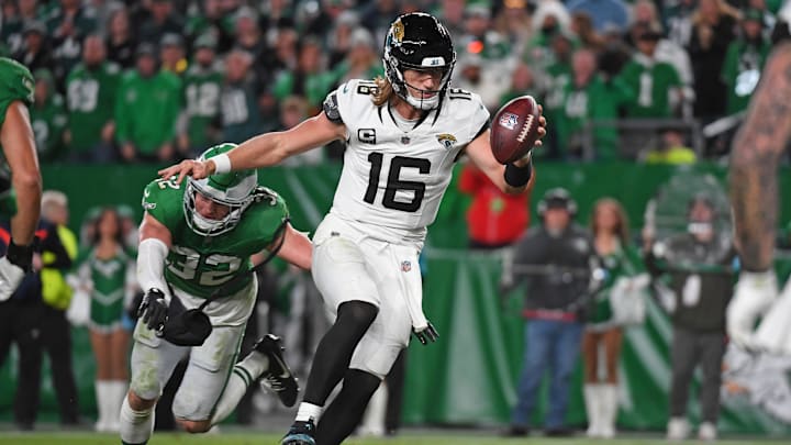 Nov 3, 2024; Philadelphia, Pennsylvania, USA; Jacksonville Jaguars quarterback Trevor Lawrence (16) scores a touchdown  past Philadelphia Eagles safety Reed Blankenship (32) during the fourth quarter at Lincoln Financial Field. Mandatory Credit: Eric Hartline-Imagn Images