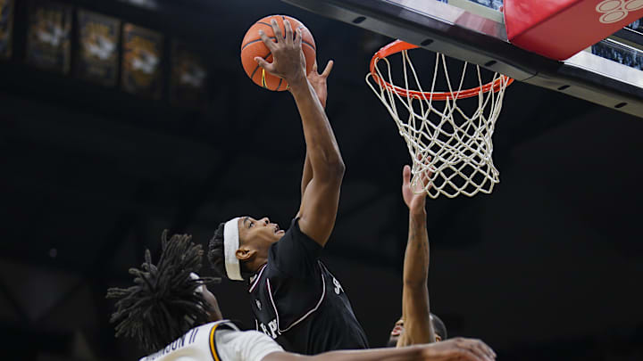Feb 8, 2025; Columbia, Missouri, USA; Texas A&M Aggies guard Zhuric Phelps (1) shoots against Missouri Tigers guard Anthony Robinson II (0) and guard Tony Perkins (12) during the second half at Mizzou Arena. Mandatory Credit: Jay Biggerstaff-Imagn Images