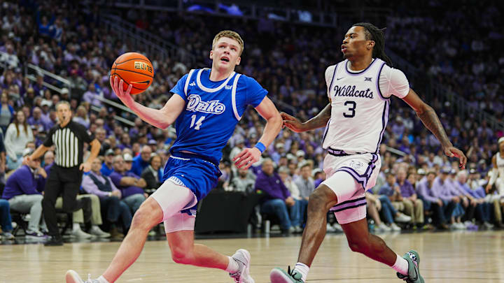 Dec 17, 2024; Kansas City, Missouri, USA; Drake Bulldogs guard Bennett Stirtz (14) drives against Kansas State Wildcats guard C.J. Jones (3) during the second half at T-Mobile Center. Mandatory Credit: Jay Biggerstaff-Imagn Images