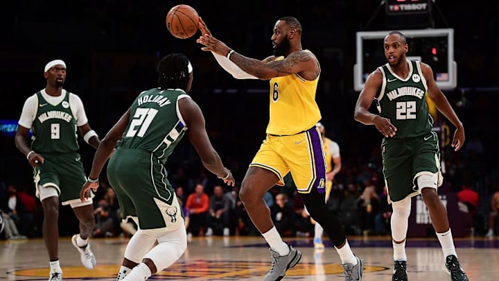 Feb 8, 2022; Los Angeles, California, USA; Los Angeles Lakers forward LeBron James (6) passes the ball against Milwaukee Bucks guard Jrue Holiday (21) and forward Khris Middleton (22) during the first half at Crypto.com Arena. Mandatory Credit: Gary A. Vasquez-Imagn Images