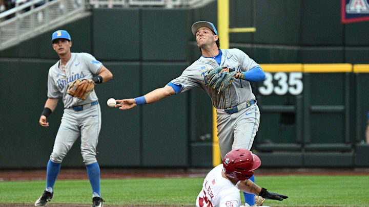 Jun 17, 2025; Omaha, Neb, USA; UCLA Bruins shortstop Roch Cholowsky (1) completes a double play after getting Arkansas Razorbacks designated hitter Kuhio Aloy (25) out during the first inning at Charles Schwab Field. Mandatory Credit: Steven Branscombe-Imagn Images Jun 17, 2025; Omaha, Neb, USA; UCLA Bruins shortstop Roch Cholowsky (1) completes a double play after getting Arkansas Razorbacks designated hitter Kuhio Aloy (25) out during the first inning at Charles Schwab Field. Mandatory Credit: Steven Branscombe-Imagn Images