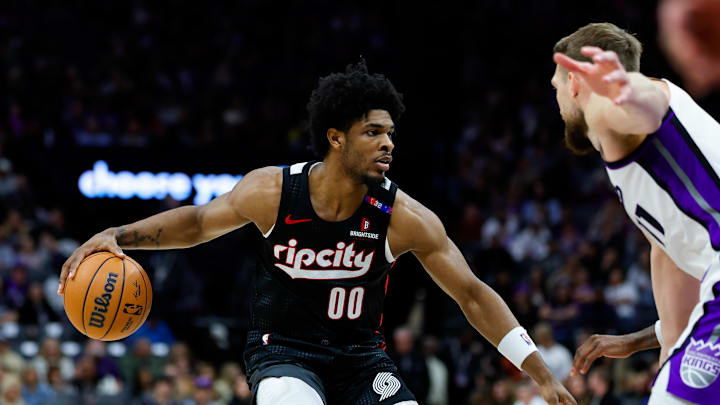 Mar 27, 2025; Sacramento, California, USA; Portland Trail Blazers guard Scoot Henderson (00) dribbles against Sacramento Kings forward Domantas Sabonis (11) during the third quarter at Golden 1 Center. Mandatory Credit: Sergio Estrada-Imagn Images