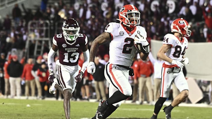 Nov 12, 2022; Starkville, Mississippi, USA;  Georgia Bulldogs running back Kendall Milton (2) runs the ball against Mississippi State Bulldogs cornerback Emmanuel Forbes (13) during the fourth quarter at Davis Wade Stadium at Scott Field. Mandatory Credit: Matt Bush-Imagn Images