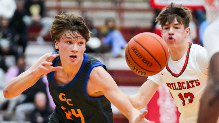 Greenfield-Central Cougars guard Braylon Mullins (24) and Lawrence North Wildcats guard Duke Karnes (13) chase after a loose ball Saturday, Dec. 14, 2024, during an Indiana High School Basketball FORUM Tipoff Classic game between Lawrence North and Greenfield-Central at Southport Fieldhouse in Indianapolis.
