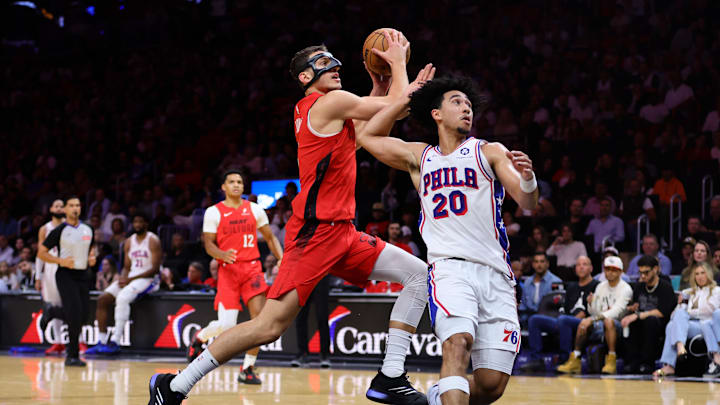 Nov 18, 2024; Miami, Florida, USA; Miami Heat forward Nikola Jovic (5) drives to the basket past Philadelphia 76ers guard Jared McCain (20) during the second quarter at Kaseya Center. Mandatory Credit: Sam Navarro-Imagn Images