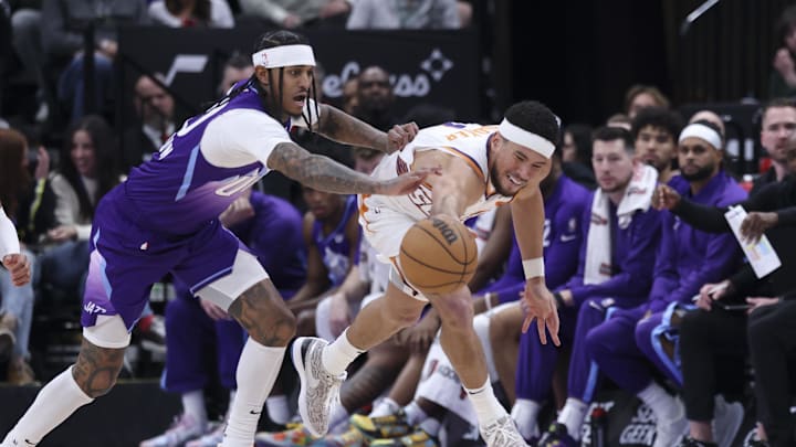 Dec 13, 2024; Salt Lake City, Utah, USA; Utah Jazz guard Jordan Clarkson (00) and Phoenix Suns guard Devin Booker (1) reach for a loose ball during the second quarter at Delta Center. Mandatory Credit: Rob Gray-Imagn Images Dec 13, 2024; Salt Lake City, Utah, USA; Utah Jazz guard Jordan Clarkson (00) and Phoenix Suns guard Devin Booker (1) reach for a loose ball during the second quarter at Delta Center. Mandatory Credit: Rob Gray-Imagn Images