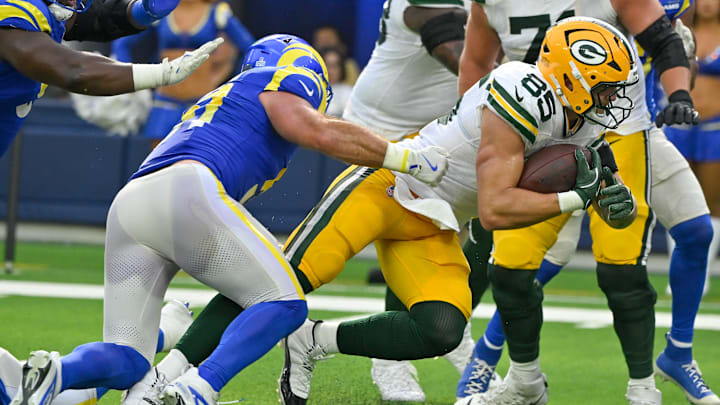 Oct 6, 2024; Inglewood, California, USA; Green Bay Packers tight end Tucker Kraft (85) breaks a tackle by Los Angeles Rams linebacker Troy Reeder (51) and scores a touchdown in the third quarter at SoFi Stadium. Mandatory Credit: Robert Hanashiro-Imagn Images